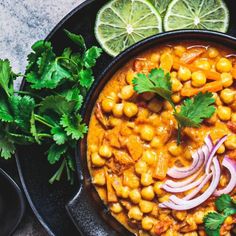 a black bowl filled with chickpeas and garnished with cilantro