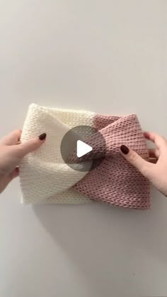 two hands are holding up a knitted blanket with the video below it that shows how to crochet