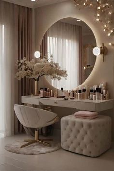 a white chair sitting in front of a vanity with lights on the wall and a mirror above it