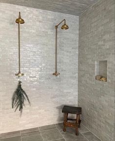 a white tiled bathroom with a bench and shower head