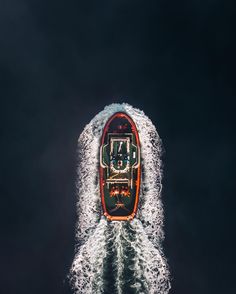 an aerial view of a boat in the middle of the ocean with water splashing around it