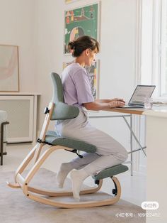 a man sitting at a desk using a laptop computer and standing on a rocking chair