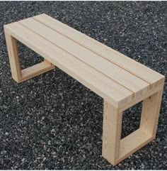 a wooden bench sitting on top of gravel