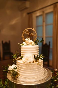 A 2 tier white frosted cake with a Mr. & Mrs. Le topper White Decor Wedding, Engagement Cake Images, Wedding Cake Two Tier, Wedding Reception Cake, Wedding Cake Simple Elegant, 25 Anniversary Cake, White And Gold Wedding Cake, Anniversary Cake Designs, 50th Wedding Anniversary Cakes