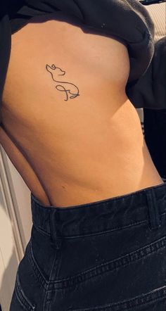 a woman's stomach with a small tattoo on her lower back and the word love written in cursive writing