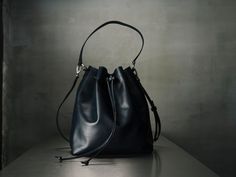 "I create my bags with high attention for details and I always respect high standards of quality. For this bag I used a soft Italian leather that gives a pleasant feeling at touch and I added all the features you would like to have on a bucket bag. The inside is fully lined and it has 3 pockets, one of them closed with a zipper for quick-access items, where you can keep your keys, your phone and other small thing that we normally lose in the abyss of our bags. To have a more secured bag, it clos Luxury Blue Rectangular Bucket Bag, Everyday Pouch Bags With Leather Handles, Navy Blue Bag, Work Chic, The Abyss, Leather Bucket Bag, Leather Gifts, Leather Bucket, Perforated Leather