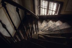 an old staircase with carpeted steps leading up to a window in the middle of it