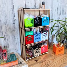 a wooden shelf filled with lots of different colored boxes and containers on top of a table