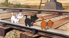 there are three dogs that are walking on the train tracks and one dog is looking at something