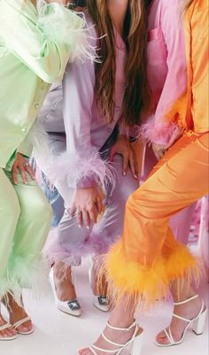 three women in colorful outfits posing for a photo