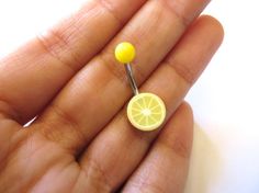 a tiny lemon on a stick in someone's hand