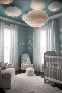 a baby's room decorated in blue and white with clouds painted on the ceiling