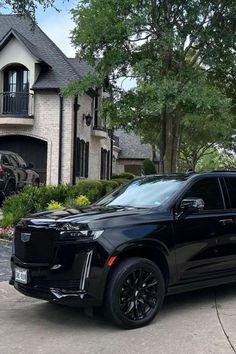 a black suv parked in front of a house