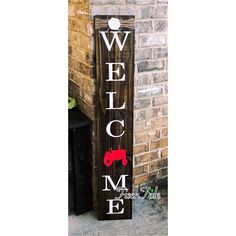 a wooden sign that says welcome to me and a red truck on the side of it