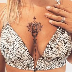 a close up of a woman's chest with a tattoo on her left side