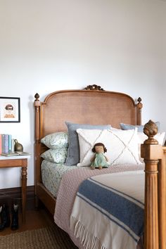 a bed with a wooden headboard and pillows on top of it, in a bedroom