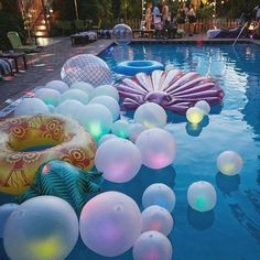 an inflatable pool filled with lots of balloons floating on top of it's surface