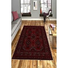 a living room filled with furniture and a red rug on top of a hard wood floor