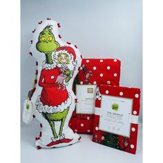 the grinch pillow is next to its packaging and some other items, including an award plaque