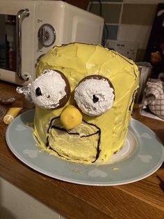 a cake that looks like the face of a cartoon character is on a plate in front of a microwave