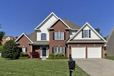 a large brick house with two garages on each side