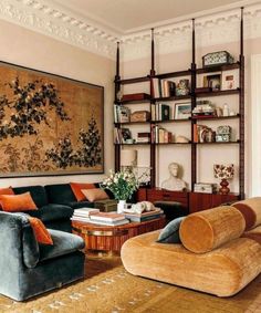 a living room filled with furniture and bookshelves next to a painting on the wall