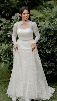 a woman in a white wedding dress posing for the camera with her hands on her hips