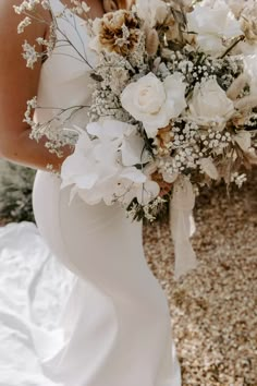 a woman in a white dress holding a bridal bouquet