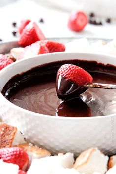 a chocolate fondant in a bowl with strawberries on the side