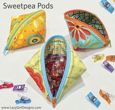 three zippered pouches sitting next to each other on a table with candy in them