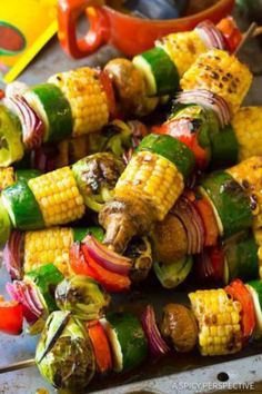 corn on the cob with peppers, onions, and other vegetables being grilled