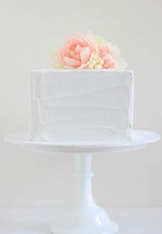 a white cake with flowers sitting on top of it