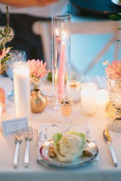 the table is set with silverware and candles