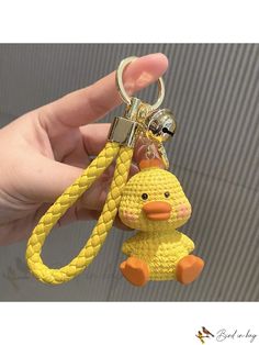 a hand holding a yellow duck key chain