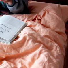 an open book sitting on top of a bed