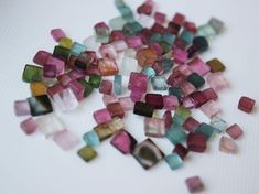 small pieces of glass sitting on top of a white table next to each other,