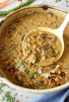 a wooden spoon in a bowl filled with mushroom soup