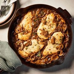 chicken with mushrooms and mushroom gravy in a cast iron skillet on a table