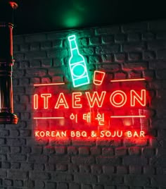 a neon sign that says taewon korean bbq and soul bar on the side of a brick wall