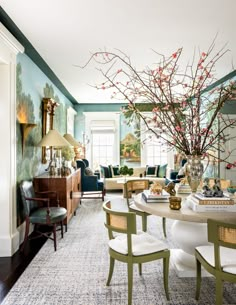 a living room filled with furniture and a large vase full of flowers on top of a table