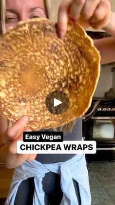 a woman holding up a chicken wrap in front of her face with the words easy vegan chickpea wraps on it