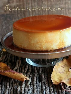 a cheesecake on a plate with leaves around it and the cake is ready to be eaten