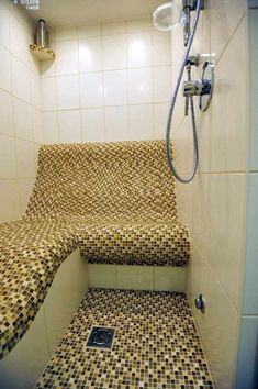 a tiled shower stall with steps leading up to it