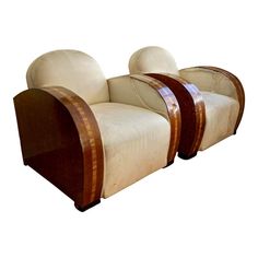 two white chairs with wooden trims on them