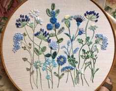 a close up of a embroidery on a hoop with blue and white flowers in it