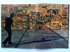 a man walking past a wall covered in graffiti