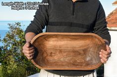 a man is holding a wooden bowl in his hands