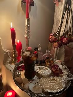 a table topped with lots of different types of food and candles next to a window