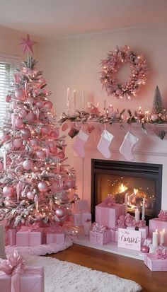 a pink christmas tree with presents under it and candles in front of the fire place