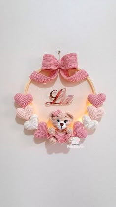 a pink teddy bear hanging from the side of a wall next to a light up sign